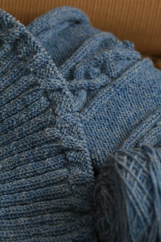 A fabric cable sleeve gathering the drop from desk to wall