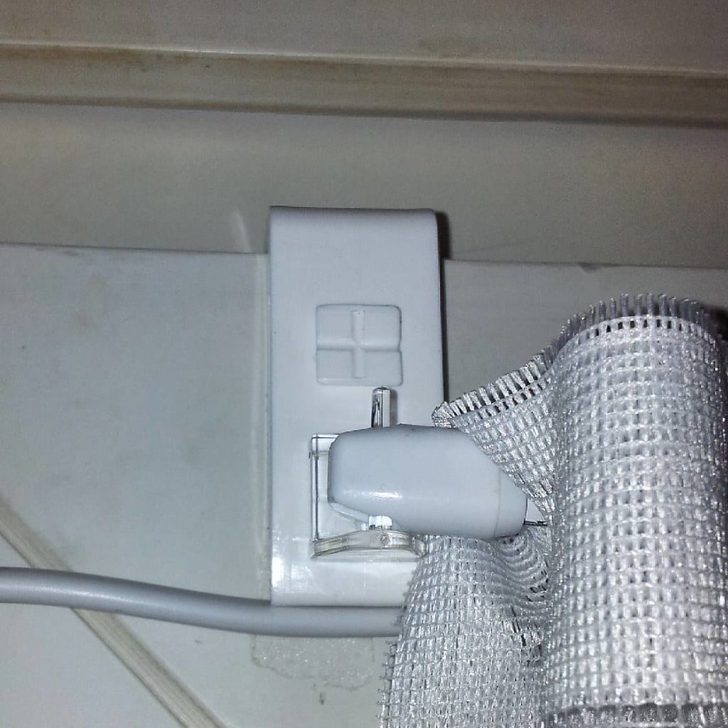 Adhesive clips routing a cable along the underside desk edge