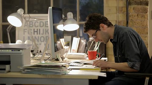 A creative professional's desk with a tablet, monitor and desk mat